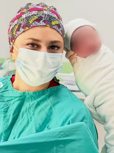 Dr. Fatimə Oruczadə cərrahi geyimdə, yenidoğulmuş körpə ilə